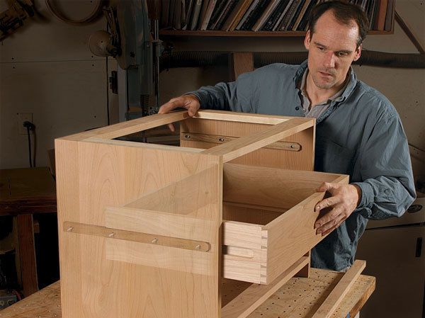 a man is working on some wooden furniture