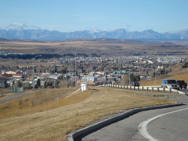 a view of a city from the top of a hill with mountains in the background