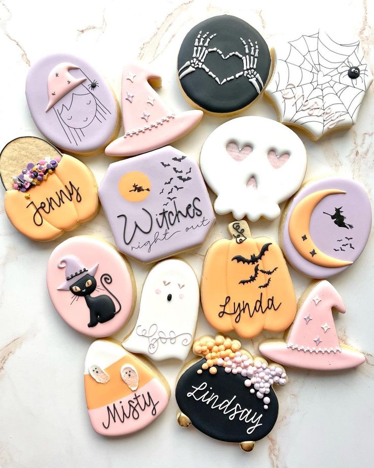 decorated cookies are arranged in the shape of witches and ghost faces with names on them