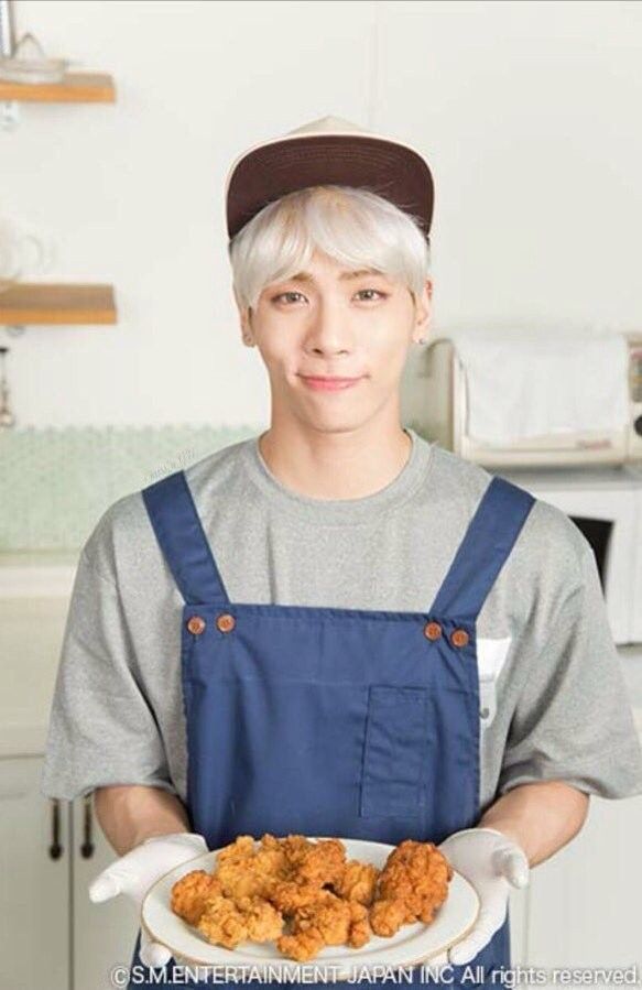 a man in an apron holding a plate of food