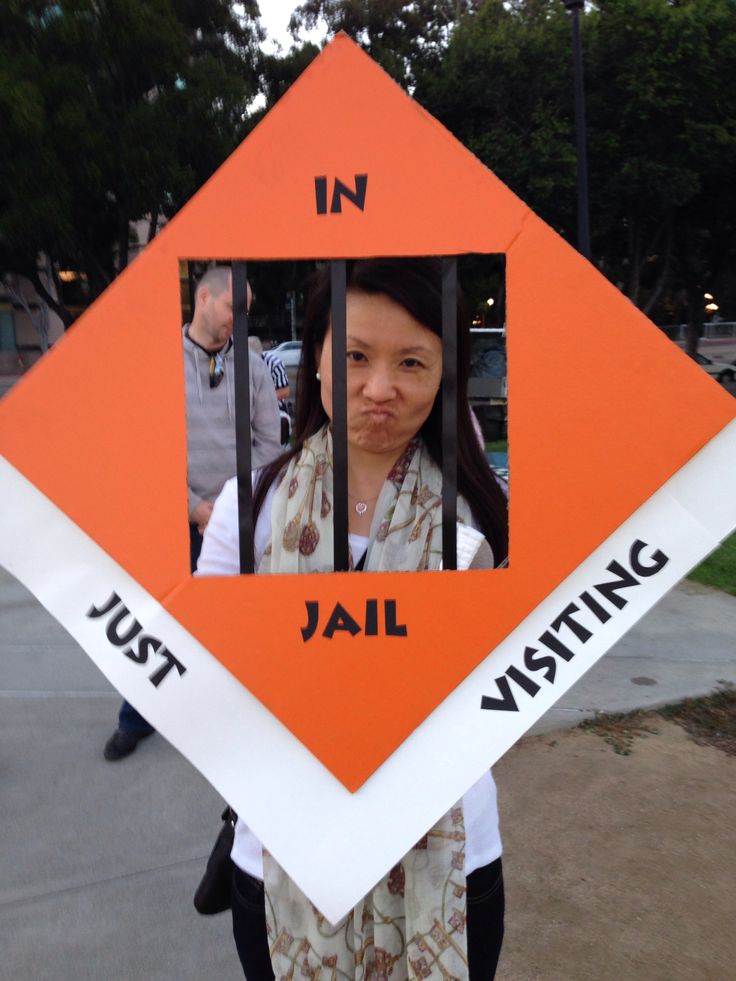 an orange diamond shaped sign with a woman behind it and the words jail written on it