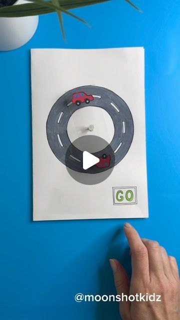 a hand is pointing at a car magnet on the wall