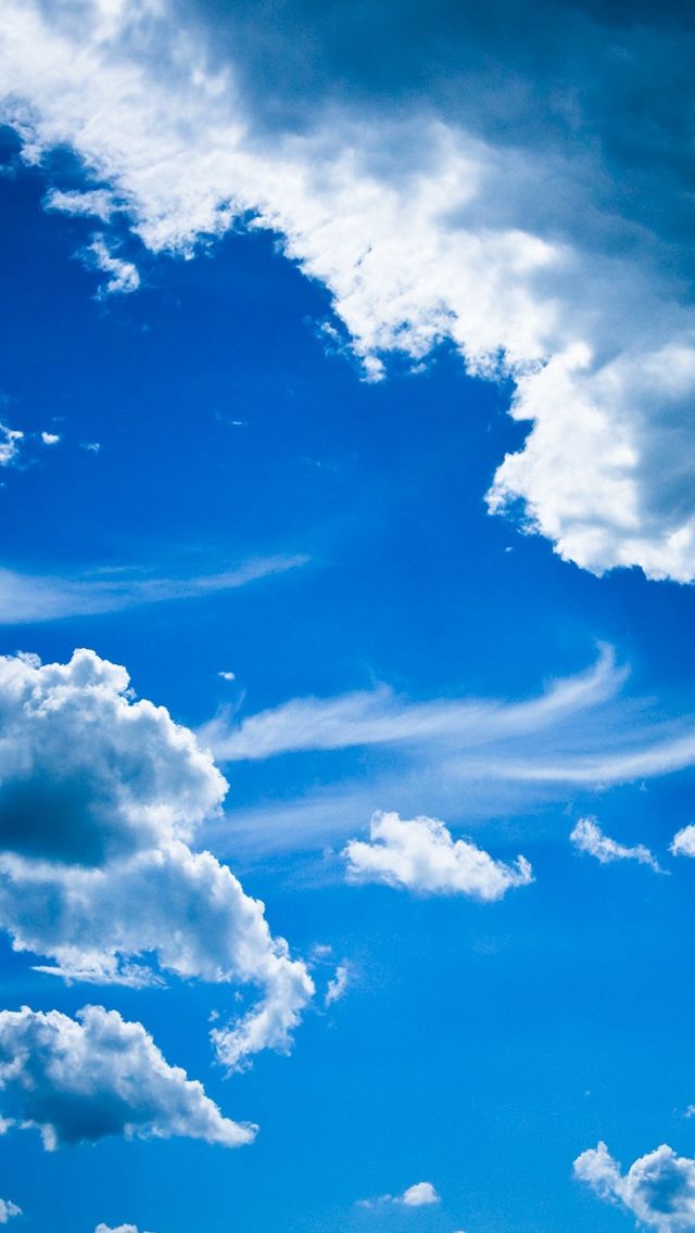 the airplane is flying high in the blue sky with white clouds above it and below