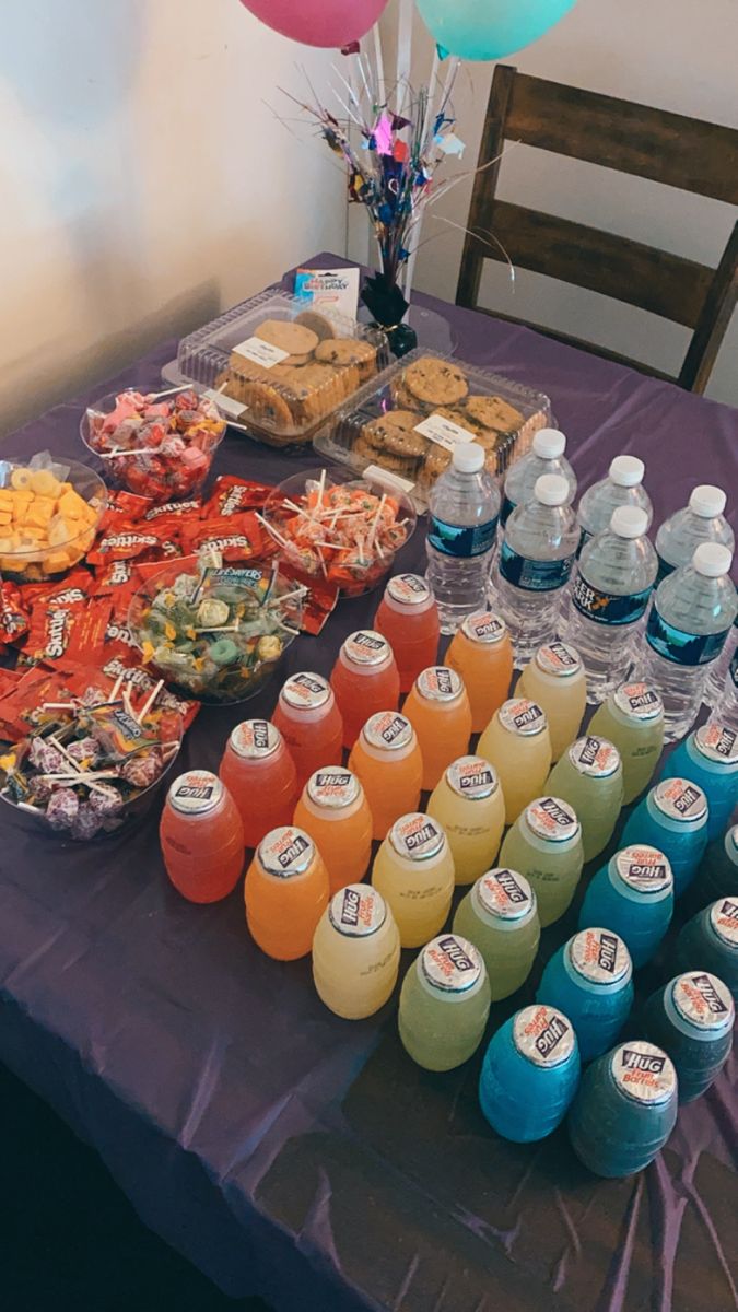 a table topped with lots of food and drinks next to balloon shaped balloons in the air