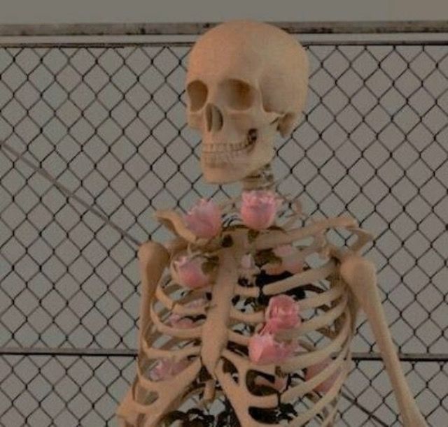 a skeleton with flowers on it's chest standing in front of a chain link fence