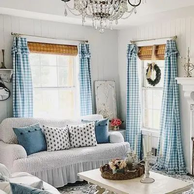 a living room filled with furniture and a chandelier hanging from the ceiling over a fire place