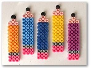 four different colored legos are arranged in the shape of pencils with black beads on them