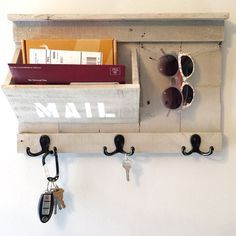 a pair of sunglasses hanging on a wall with keys and key hooks attached to it