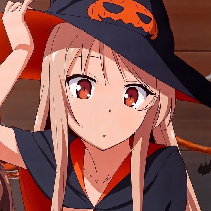 a girl in a witches hat with her hands on her head