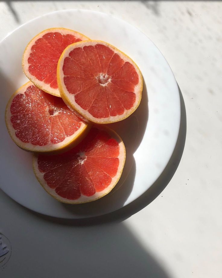 three slices of grapefruit on a white plate