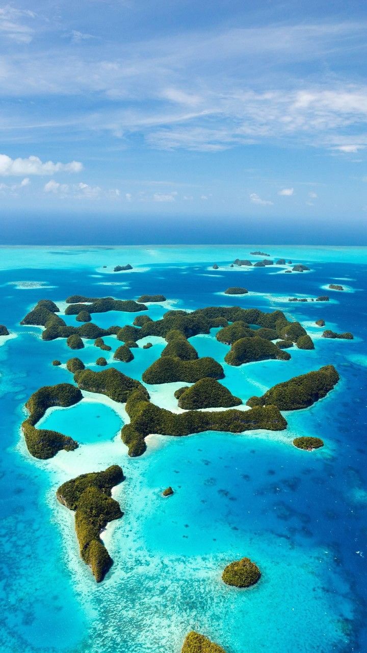 an aerial view of several small islands in the middle of the ocean with blue water