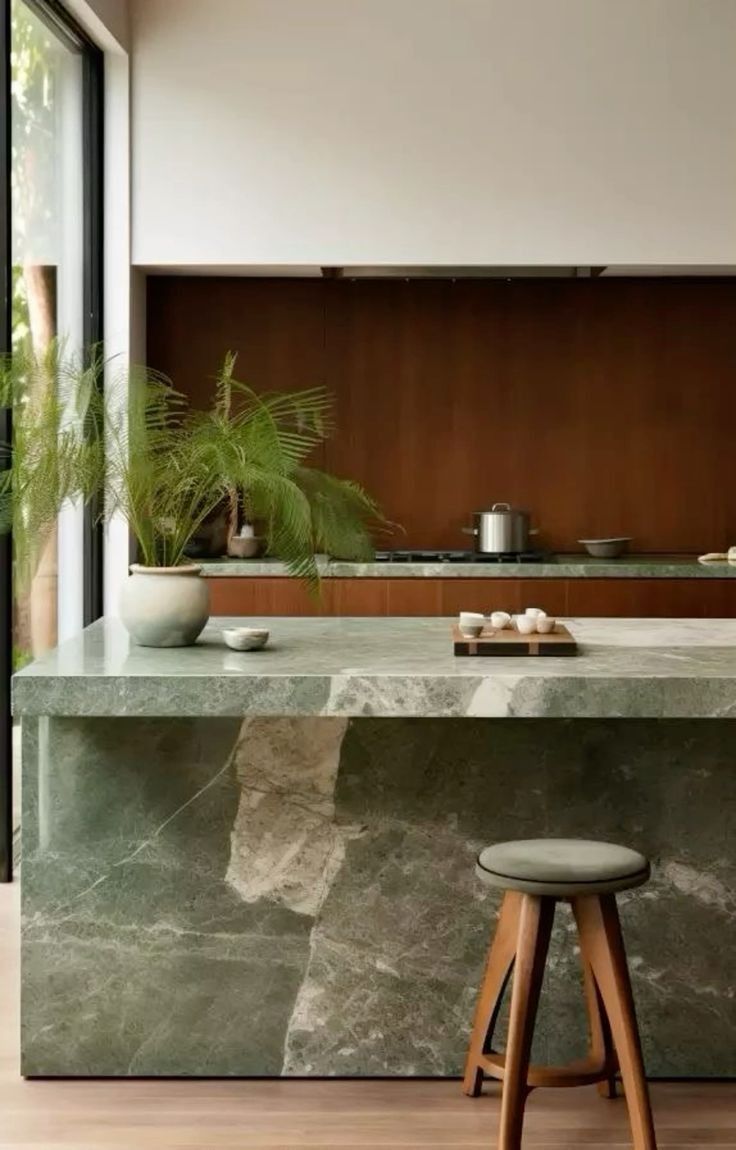 a kitchen counter with two stools in front of it and a potted plant on the counter