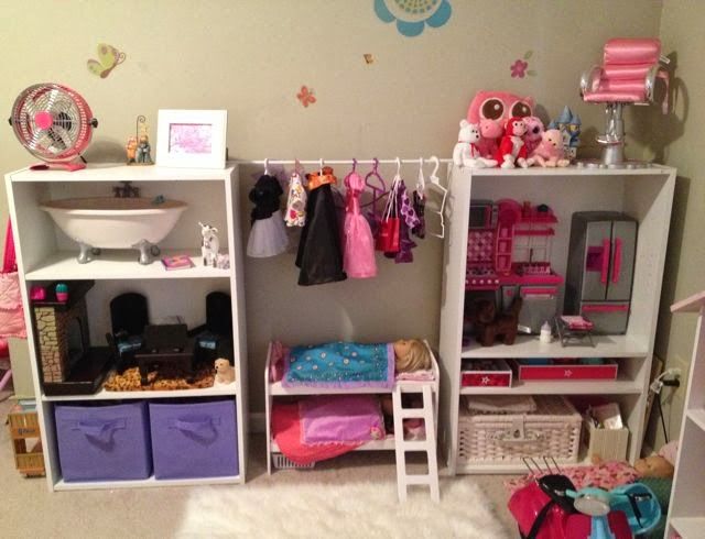 a doll house with lots of toys and accessories on the shelves in front of it