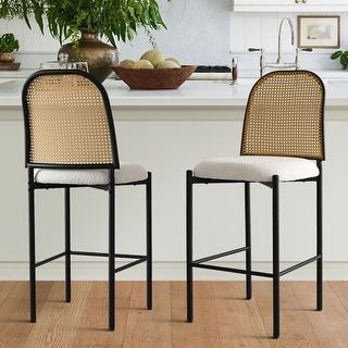 two chairs sitting on top of a wooden floor in front of a kitchen countertop