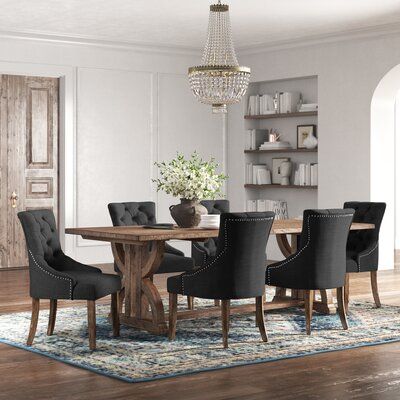 a dining room table with black chairs and a chandelier