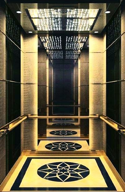 an elevator with gold walls and black flooring