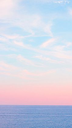 the sky is pink and blue over the ocean