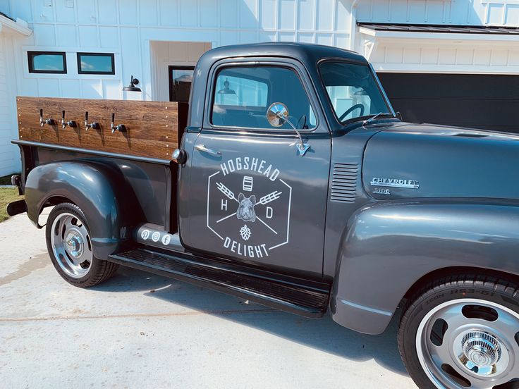 an old pickup truck parked in front of a garage