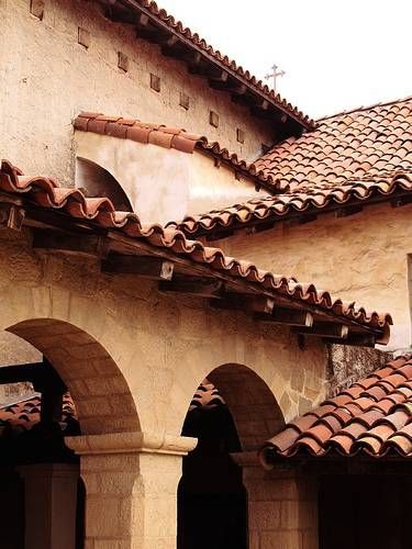 an old building with arches and tiled roof