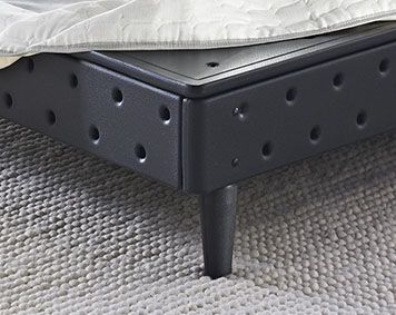 a mattress is sitting on top of a bed frame with holes in the bottom half