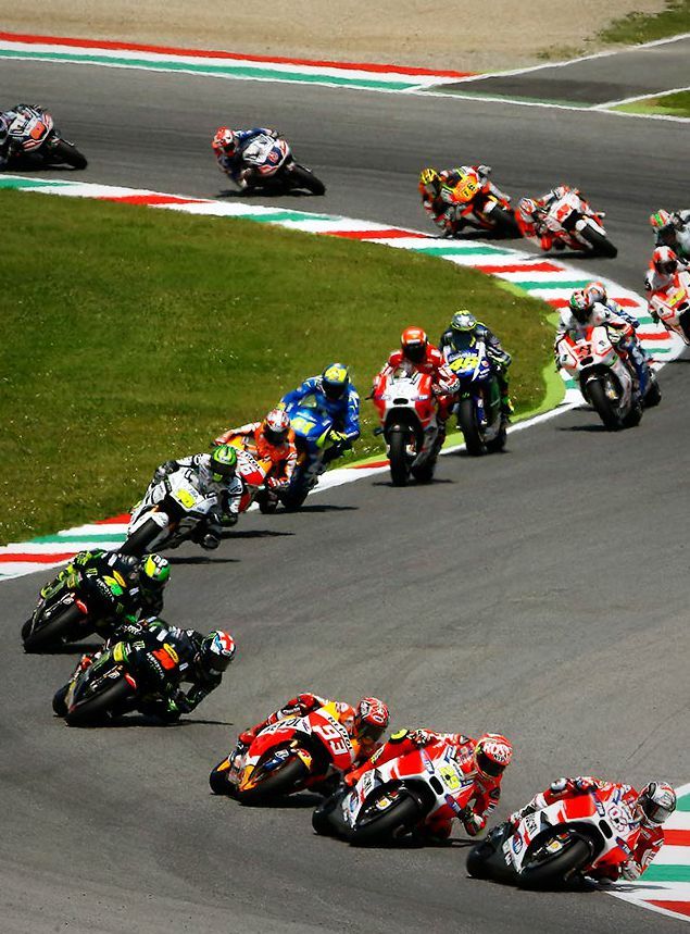 a group of motorcyclists racing on a race track