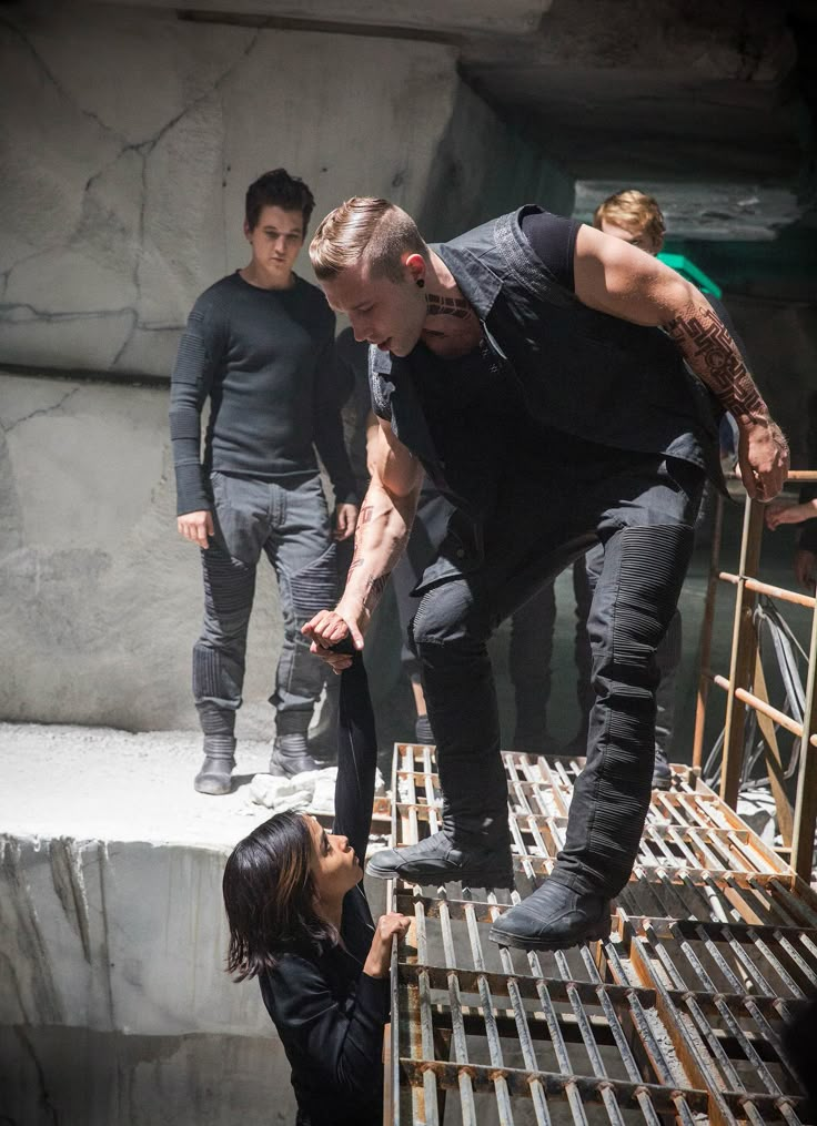 a man standing on top of a metal grate next to a woman in black