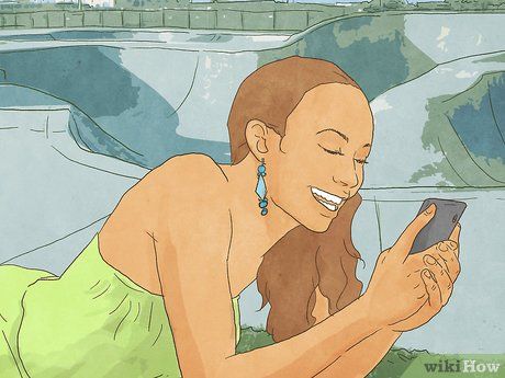 a woman is smiling while looking at her cell phone