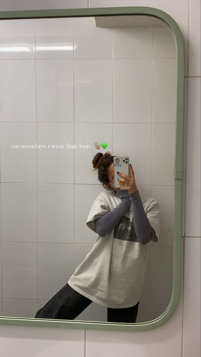 a woman taking a selfie in front of a bathroom mirror with the words on it