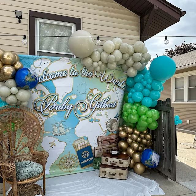 balloons are on display in front of a welcome to the west baby shower sign and suitcases