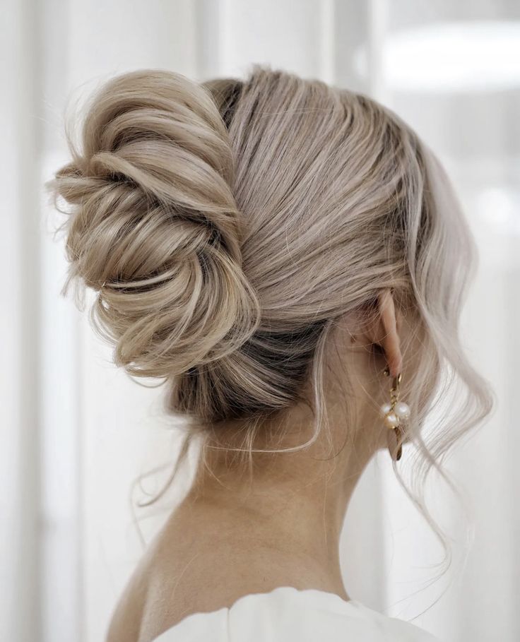 a woman with blonde hair in a low bun