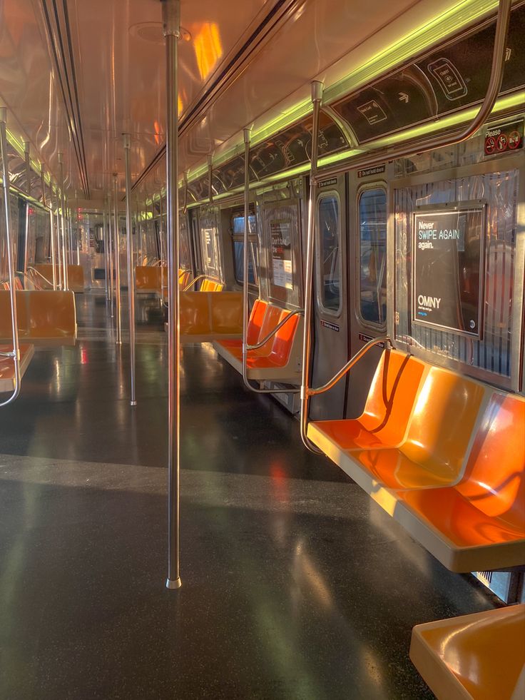 an empty subway car with orange seats