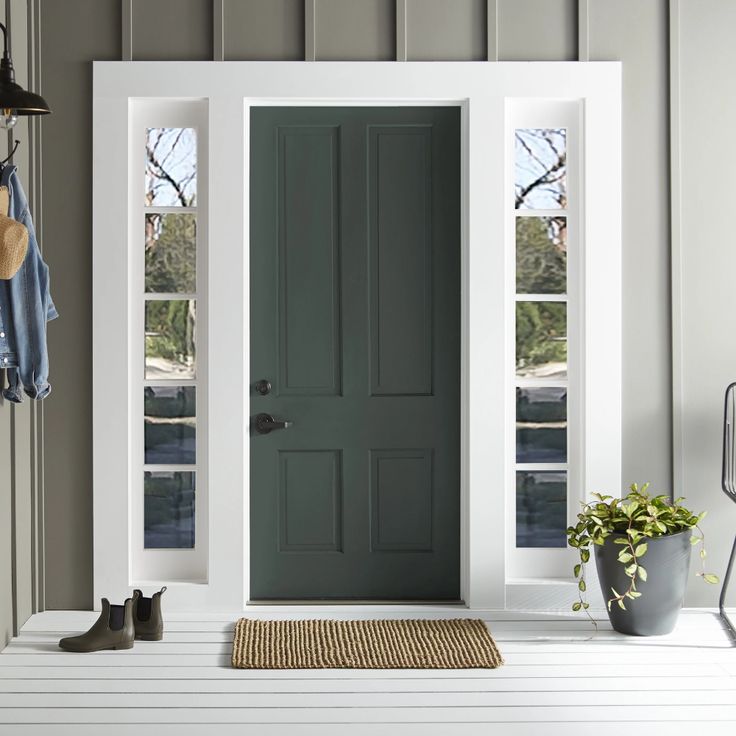 a blue front door with two windows and a rug on the floor next to it