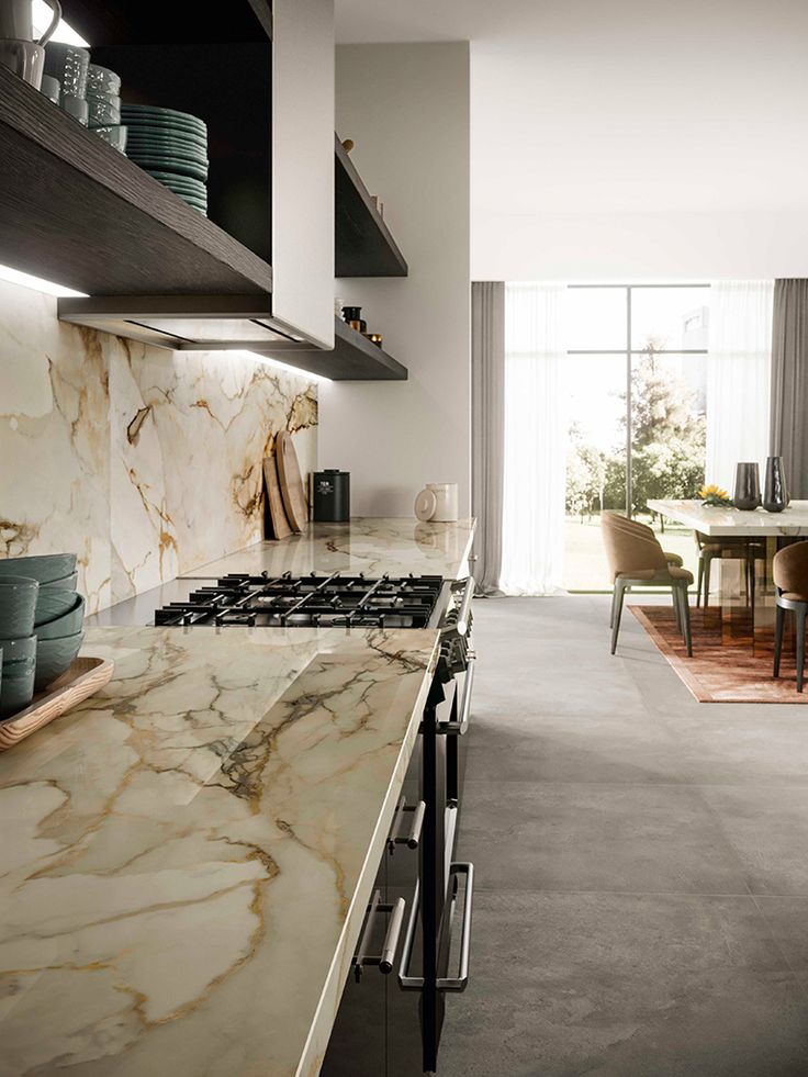 a kitchen with marble counter tops and white walls, along with an open floor plan