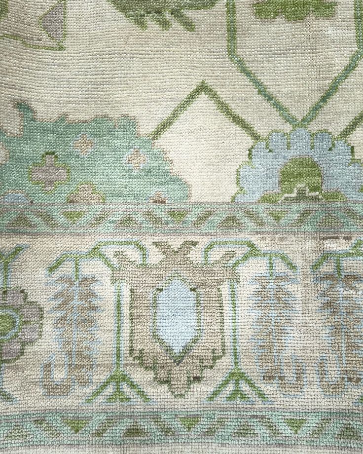 an old rug with green and blue designs on it