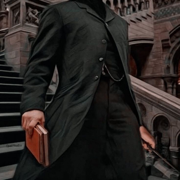 a man in a suit and tie walking down some stairs with a briefcase on his hand