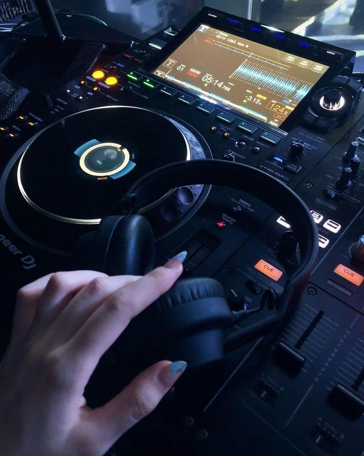 a person driving a car with headphones in front of a steering wheel and monitor