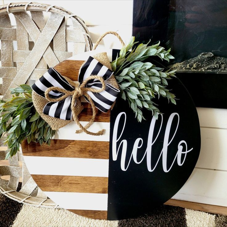 a black and white sign that says hello with a bow on it next to a basket