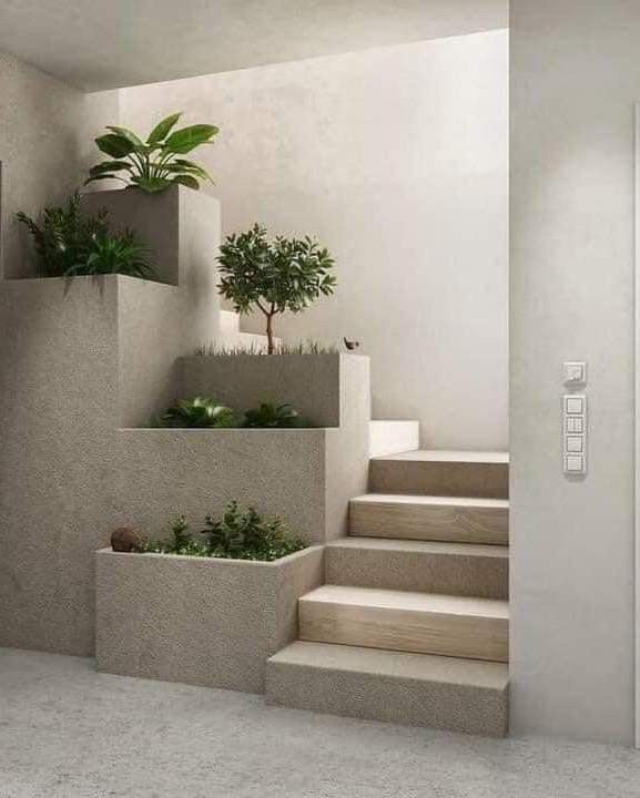 there is a planter on the top of some steps in this room with white walls