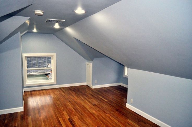 an empty room with hard wood floors and blue walls