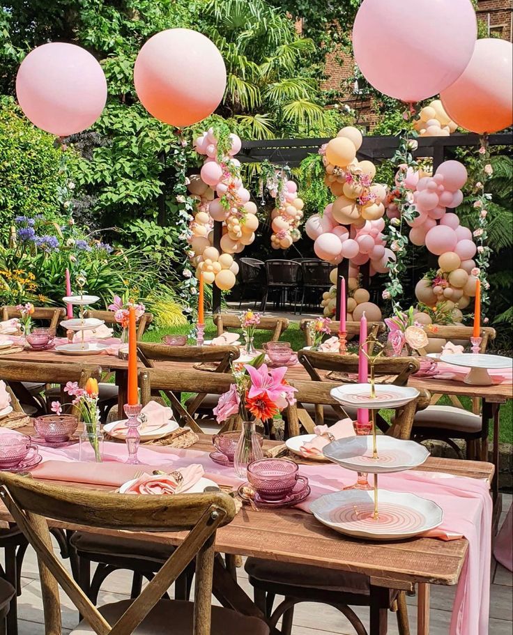 a table set up with pink and gold balloons