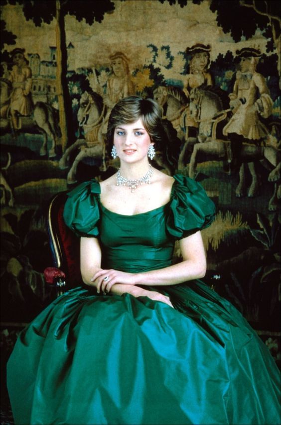 a woman in a green dress sitting on a chair