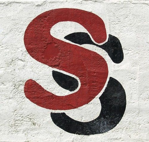 a red and black letter s on a white wall