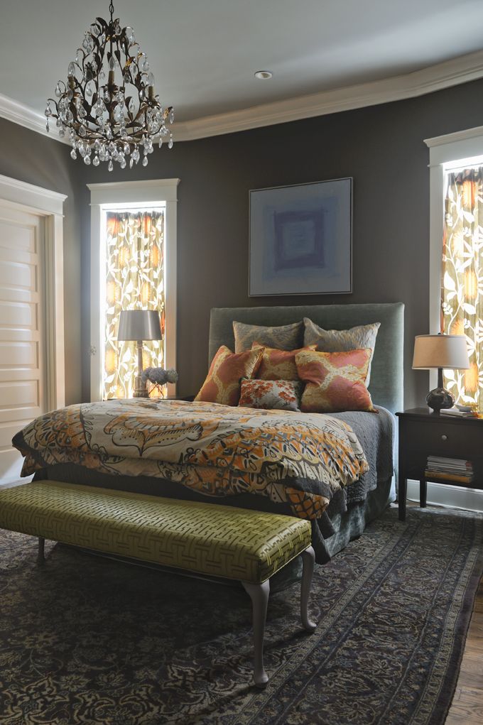 a bedroom with a bed, bench and chandelier