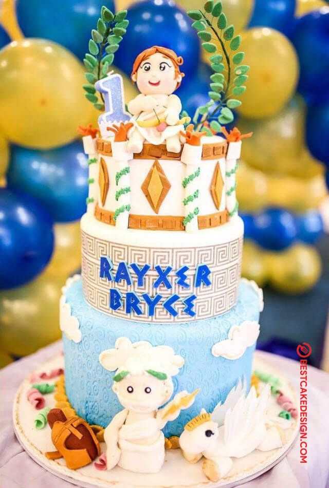 a blue and white cake sitting on top of a table with balloons in the background