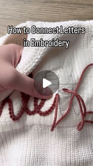 someone is stitching letters on a sweater