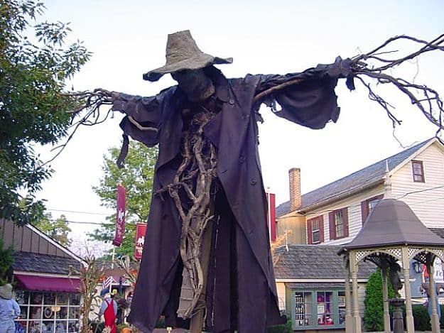 a scarecrow statue in the middle of a street