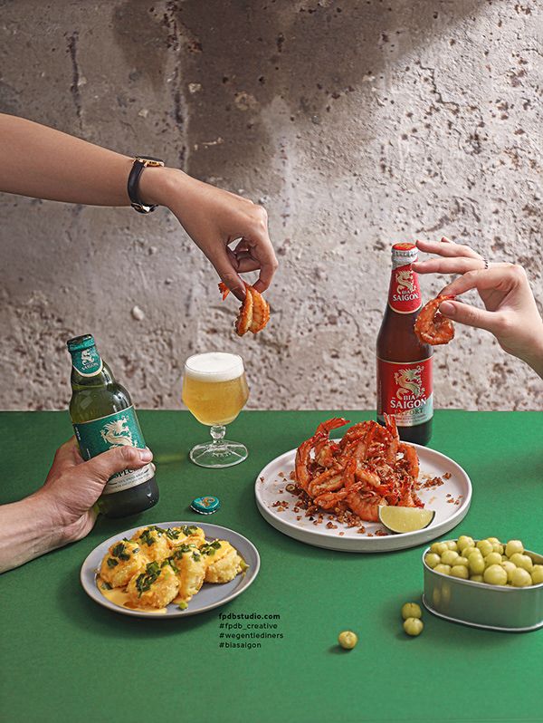 people are eating food and drinking beer at a table