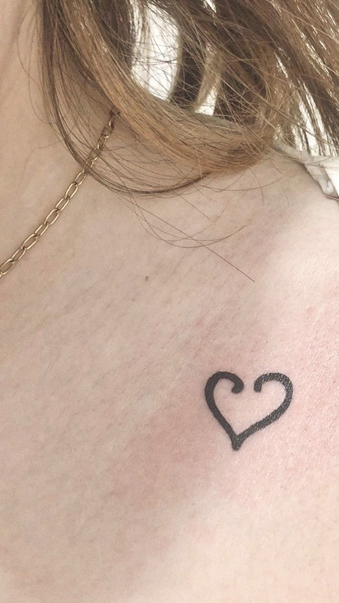 a woman with a heart tattoo on her chest