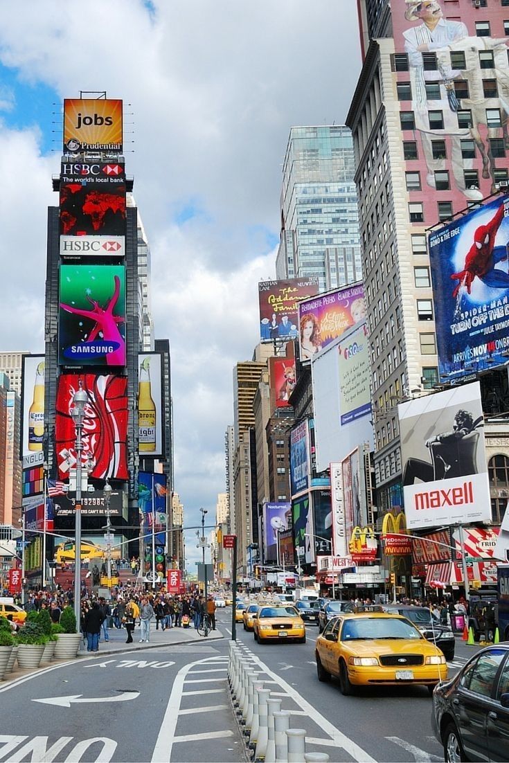 a busy city street filled with lots of traffic and tall buildings covered in billboards