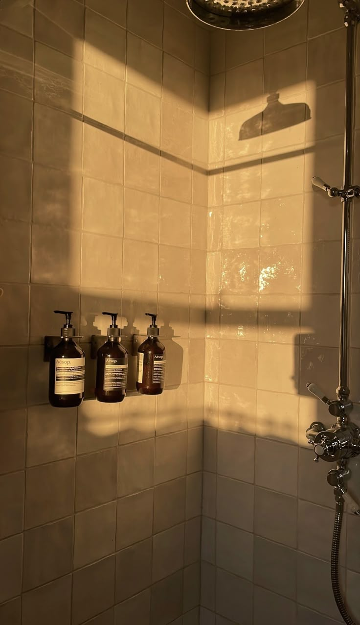 the shower head has three bottles on it